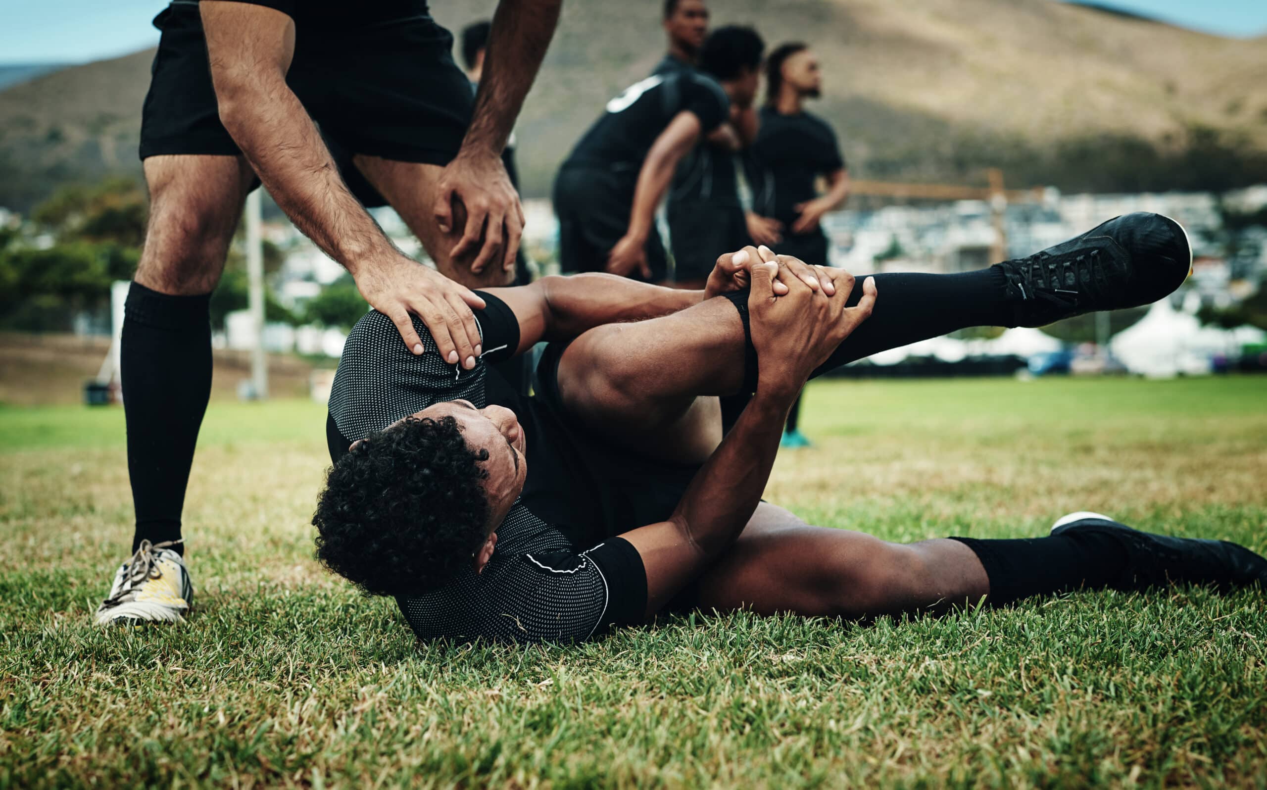 young rugby player suffering with an injury on the field.