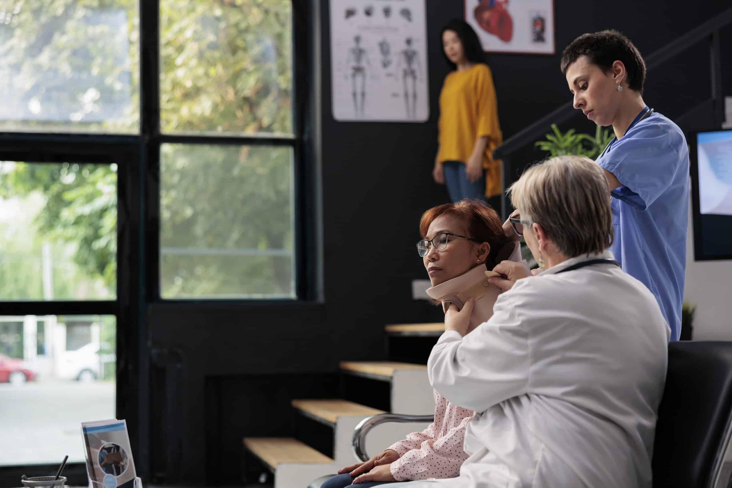 Health specialist and physician helping senior woman with foam brace giving support to remove cervical neck collar and recover. Specialists helping injured patient with fracture, medicine concept